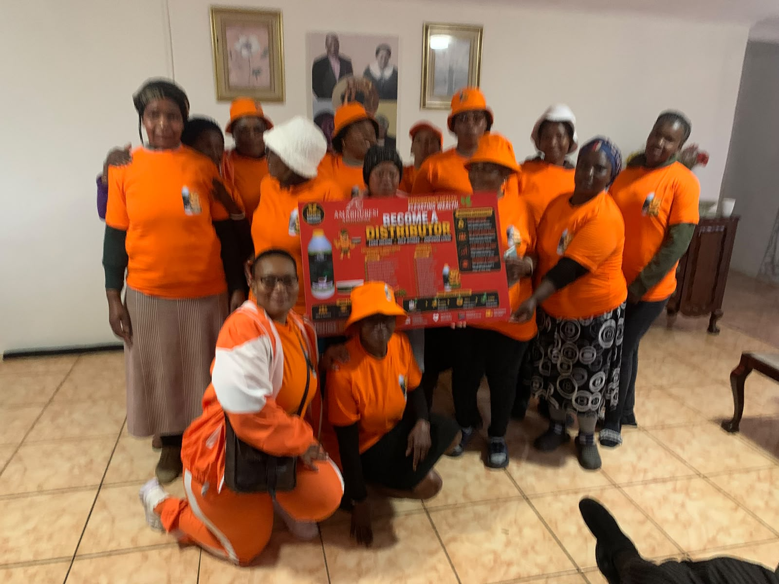 Amabhubesi Amhlophe distributors holding a Become a Distributor poster